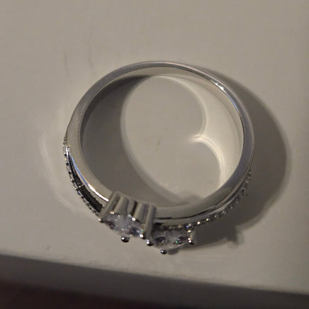 Silver ring with heart-shaped center on a light gray background
